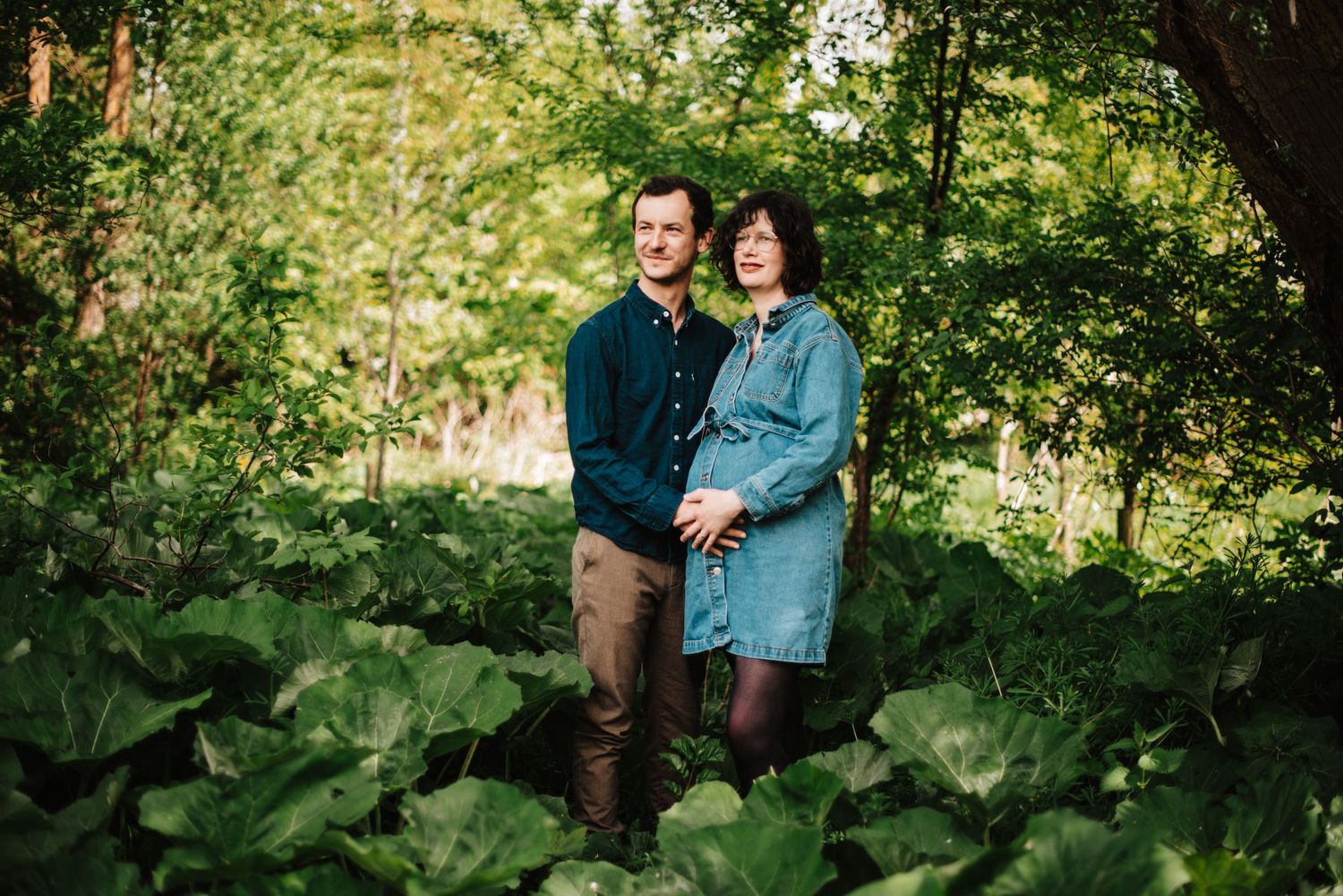 Natural outdoor maternity session in a lush garden setting.