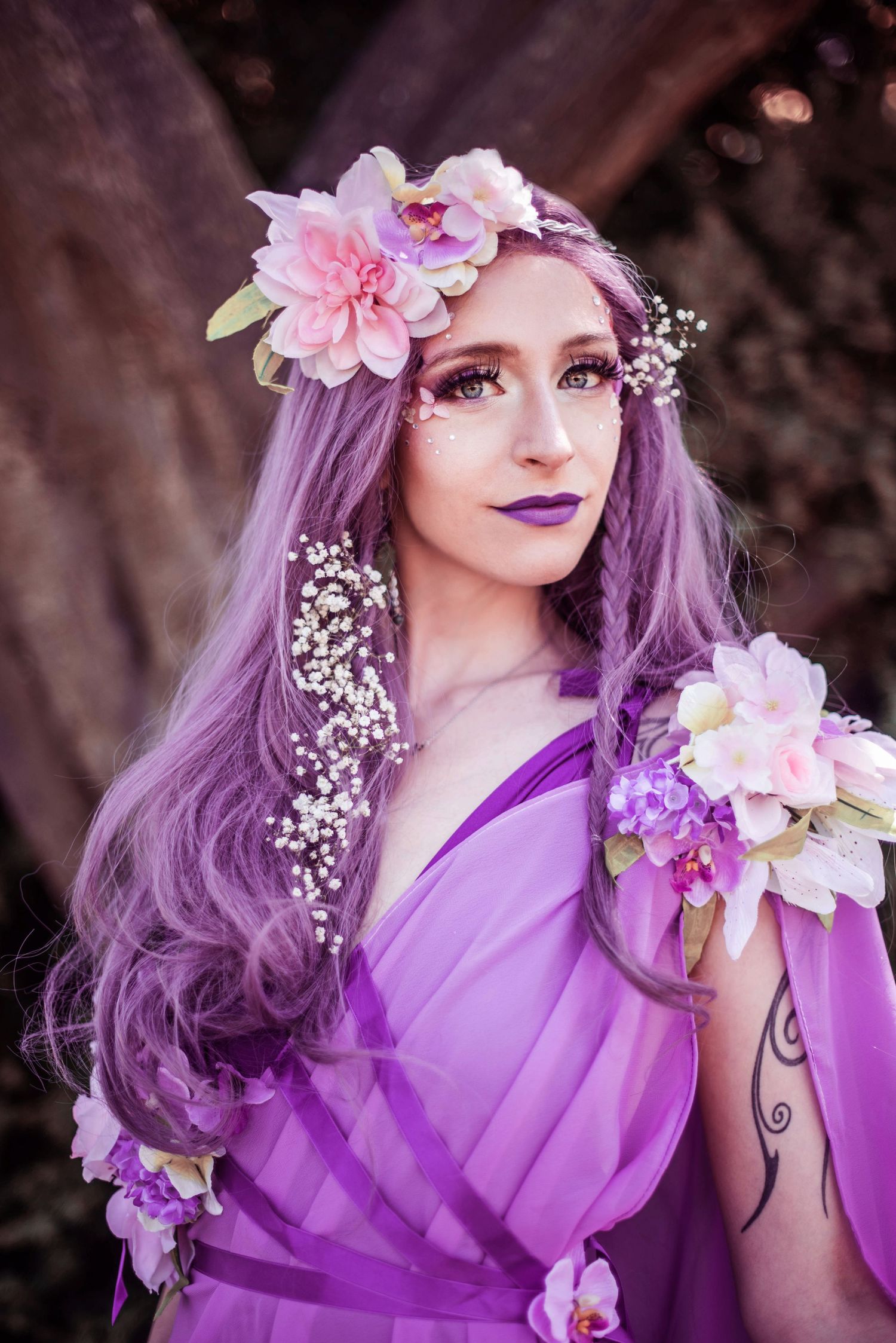 Fantasy portrait with purple hair adorned with pink flowers and delicate baby's breath.