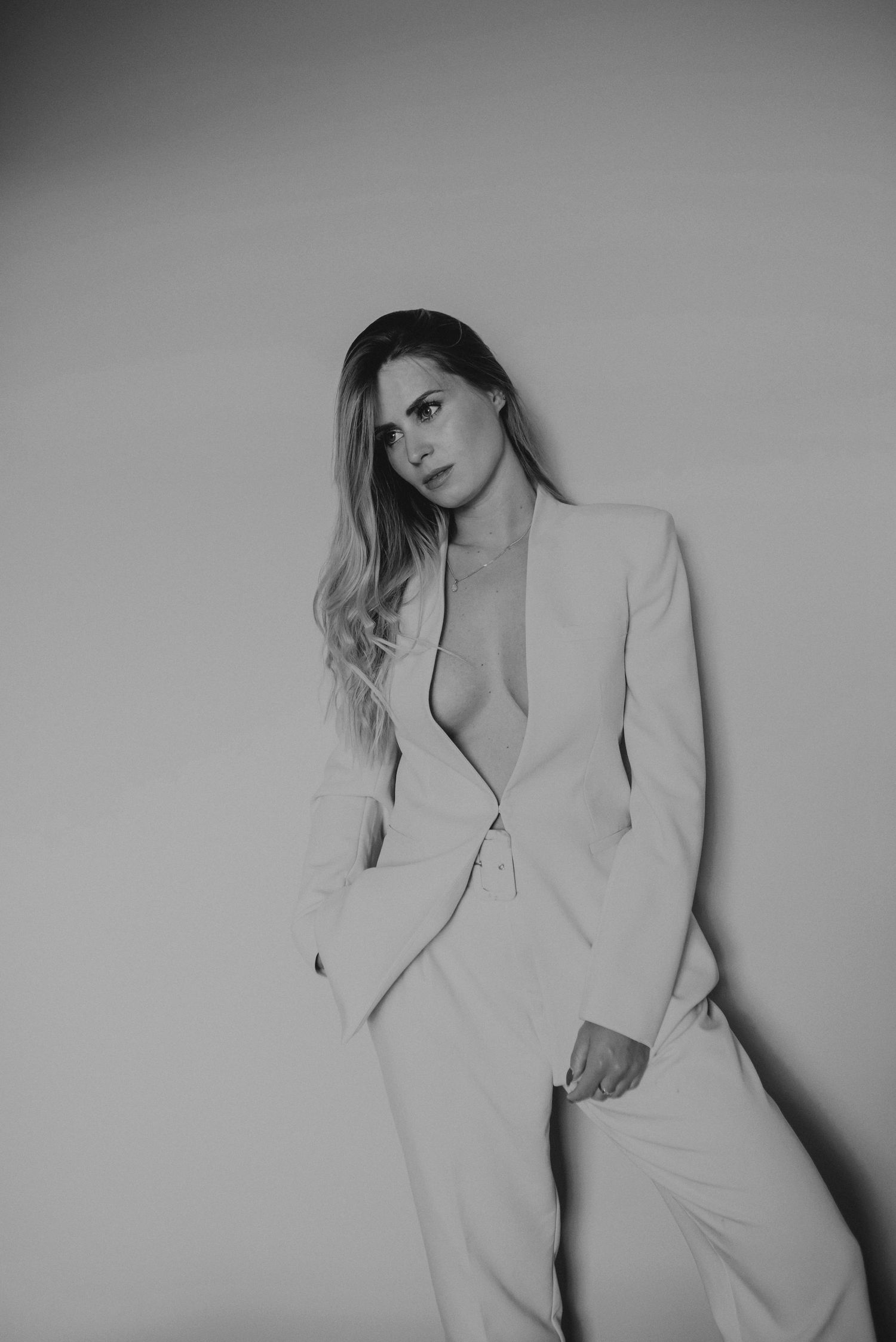 Black and white portrait series featuring a light blazer against a minimalist background.