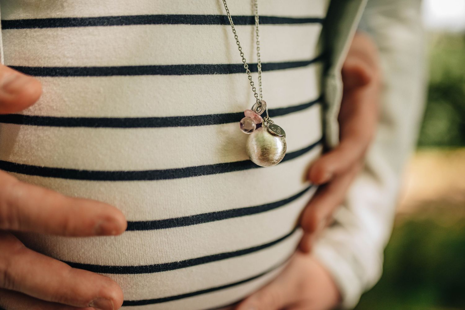Close-up shots of a striped maternity dress showing the baby bump.