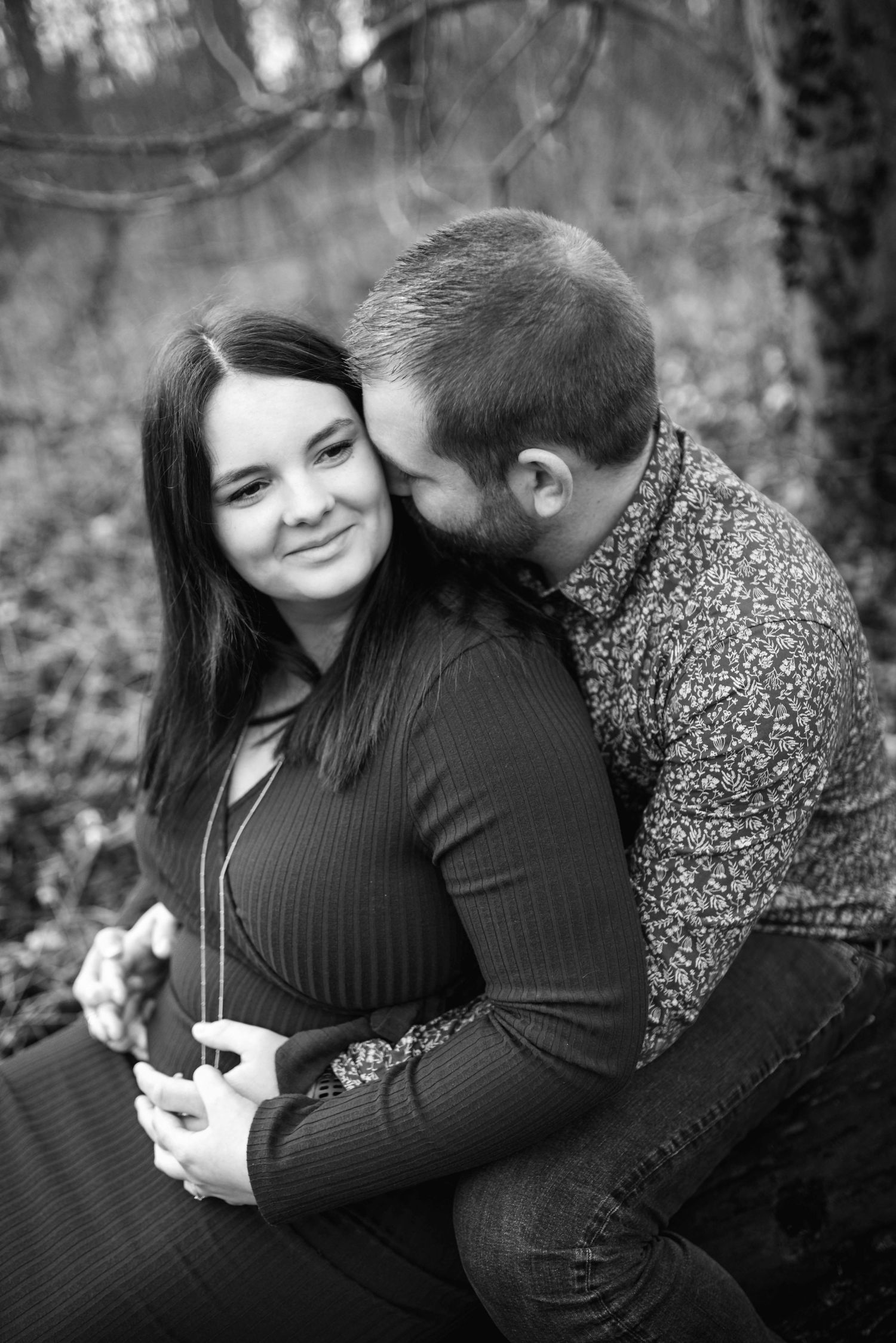 Intimate black and white maternity portraits in natural outdoor setting.