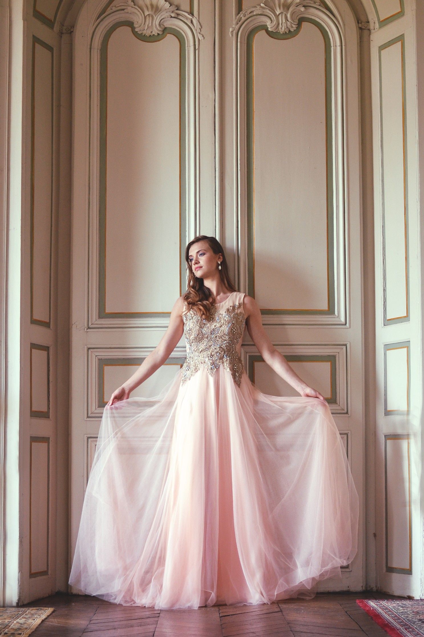 Ethereal pink tulle gown photographed in elegant room with ornate moldings and natural light.