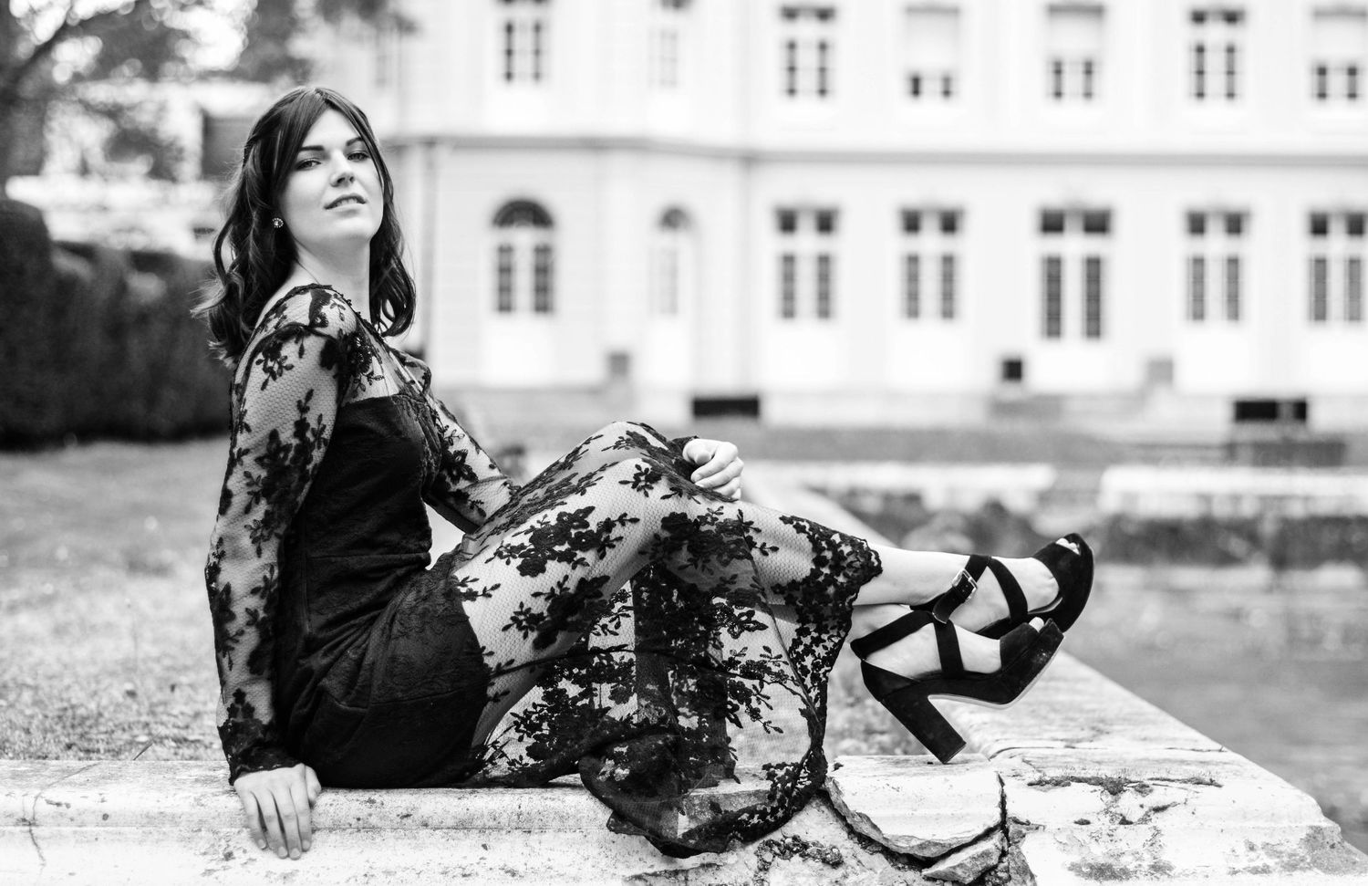 Elegant outdoor photoshoot featuring autumn trees with golden leaves in the background.