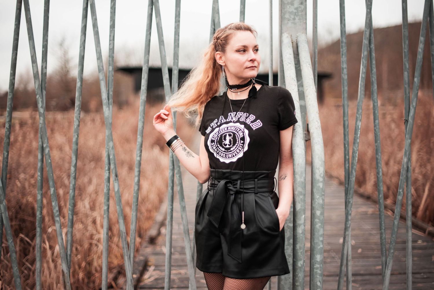 Artistic portrait series with metal fence elements creating leading lines.