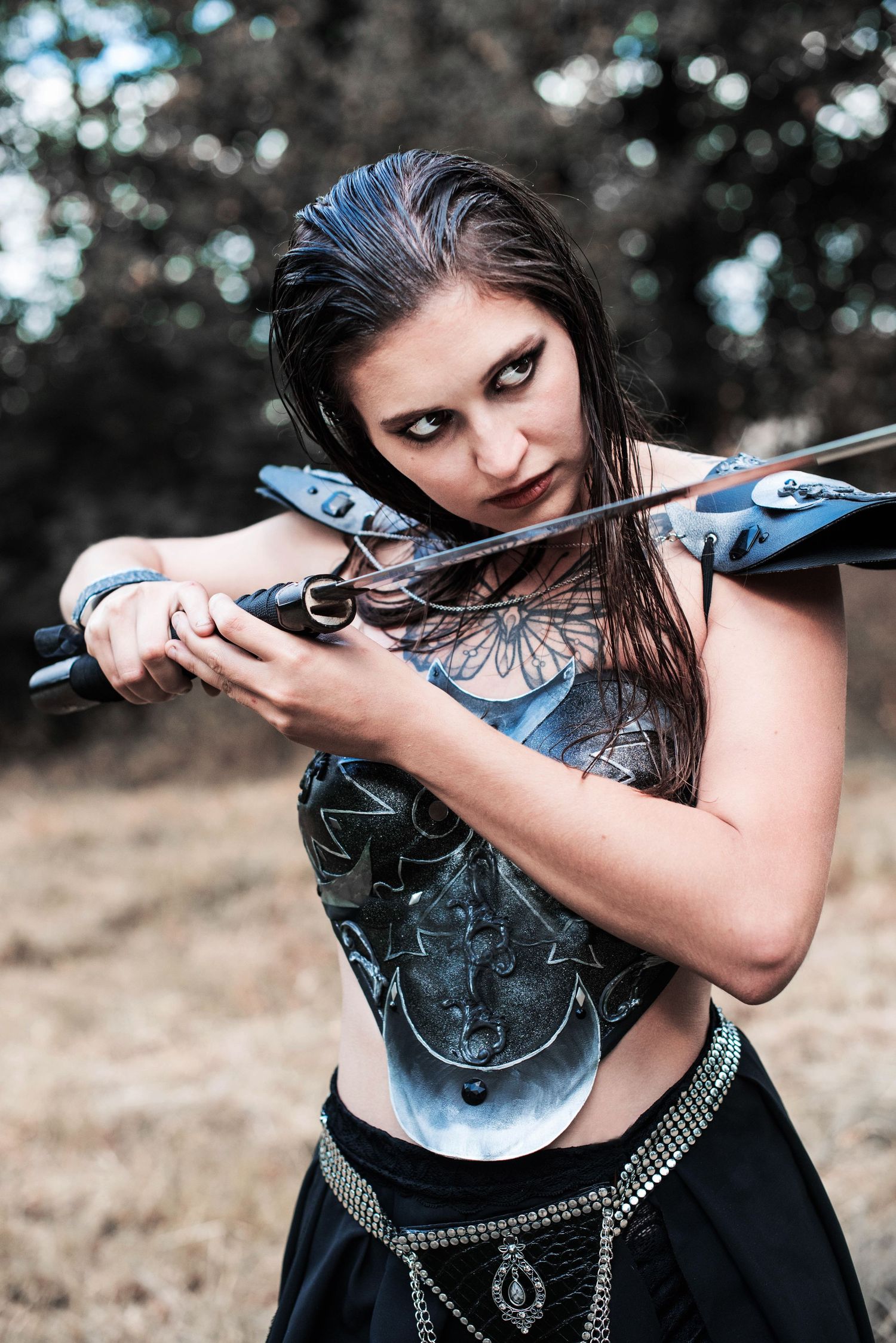 A warrior-themed photoshoot featuring armor and a sword in dramatic lighting.