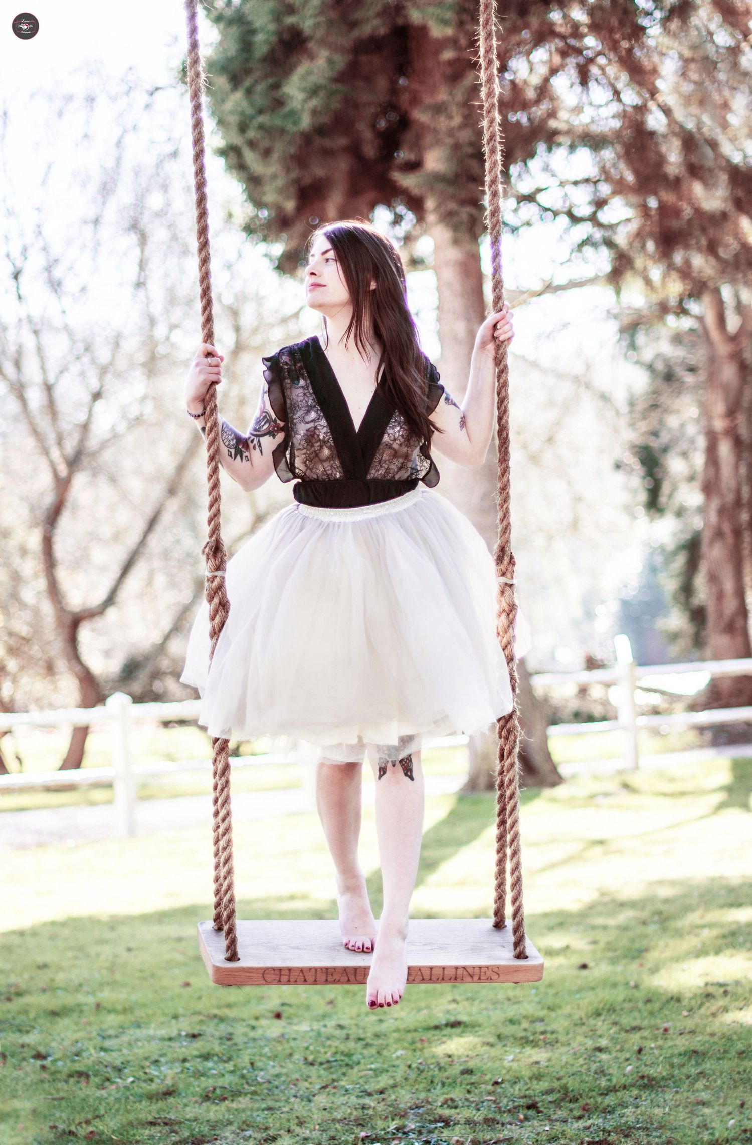 Artistic outdoor portrait on rope swing in natural setting.