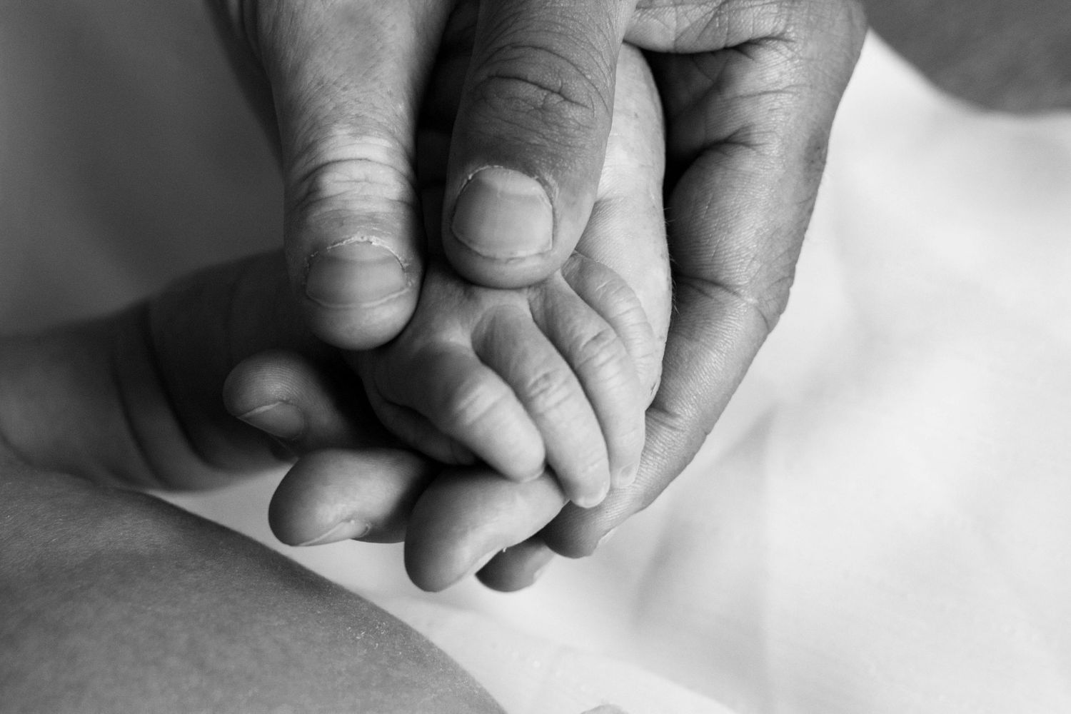 Series of black and white macro shots showing baby's tiny fingers and hands.
