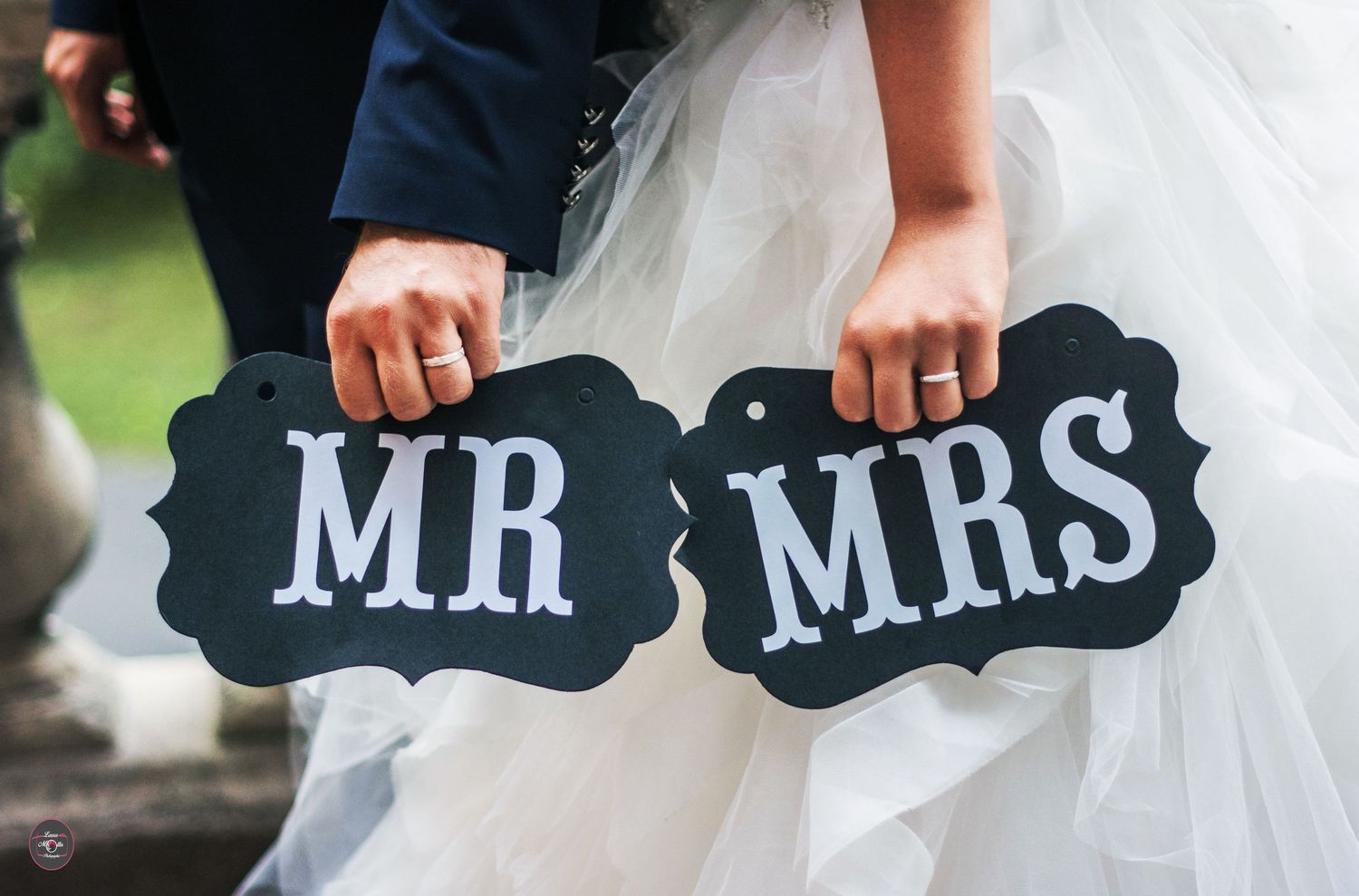 Black and white decorative signs reading Mr and Mrs being held up at a wedding celebration.