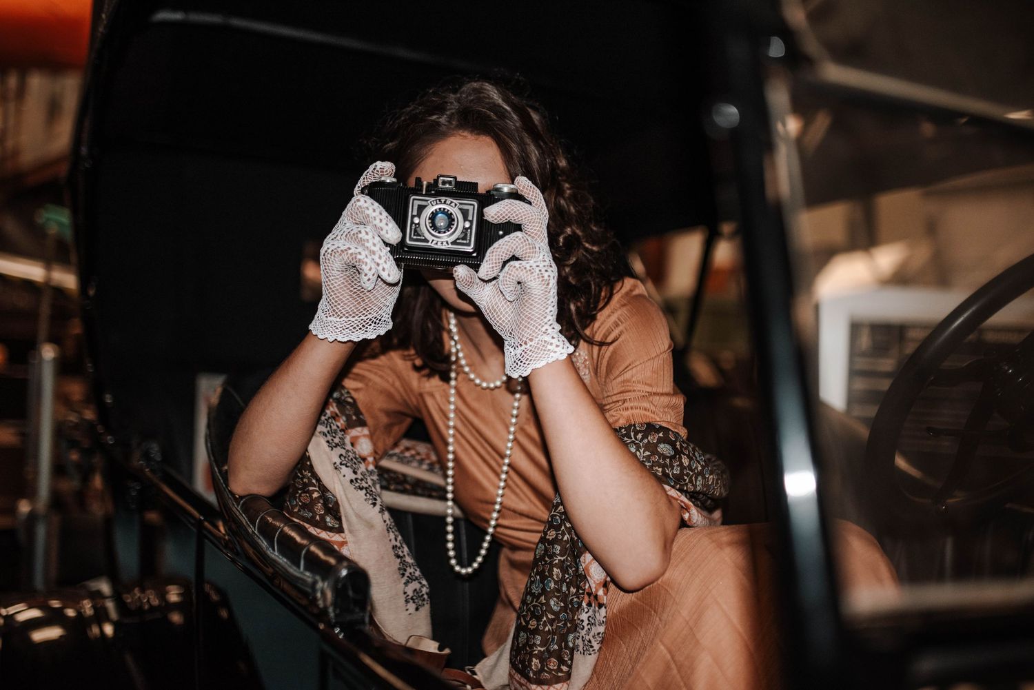 Vintage camera being held in dim lighting with artistic composition.