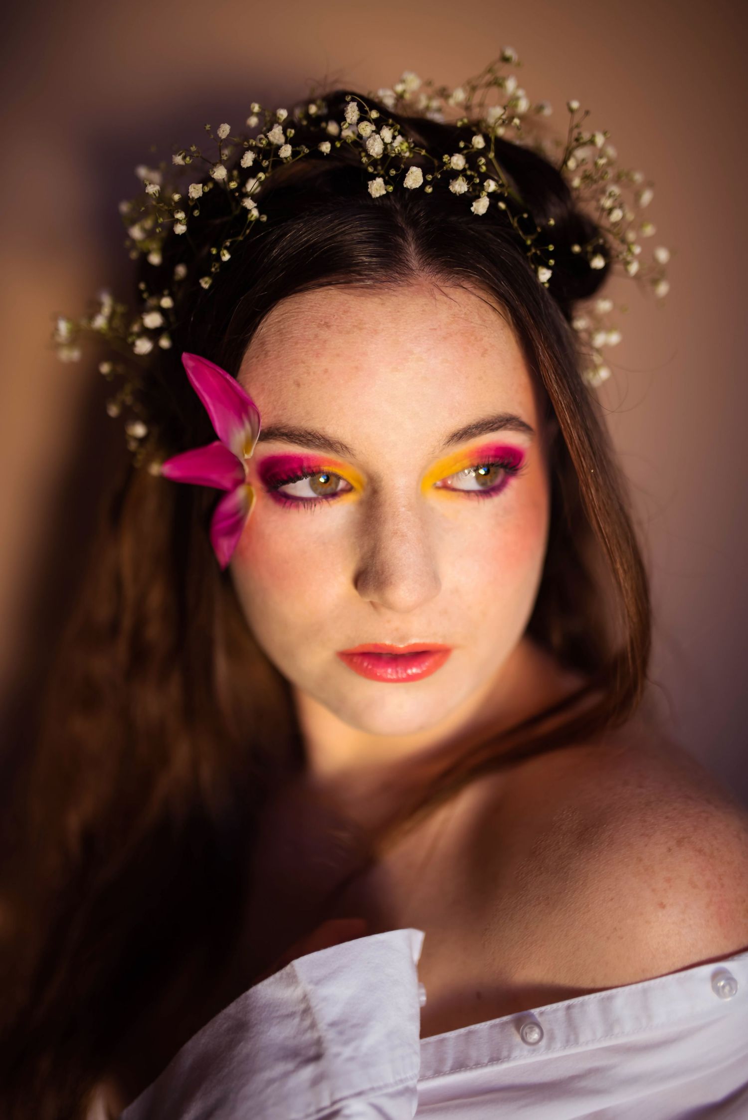 Close-up beauty shot featuring delicate floral crown and bright pink eyeshadow.