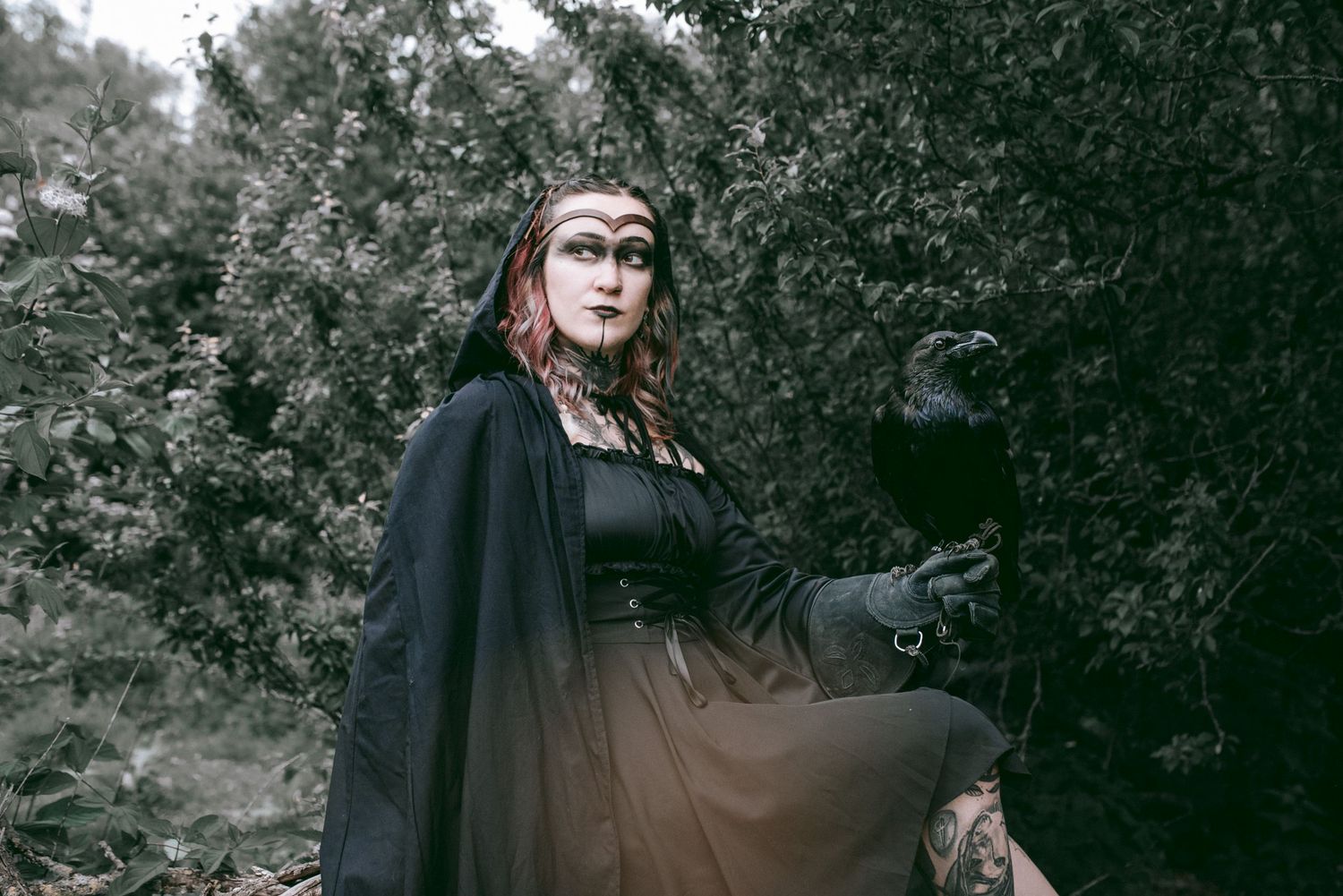 Dark atmospheric portrait in forest with flowing black dress.