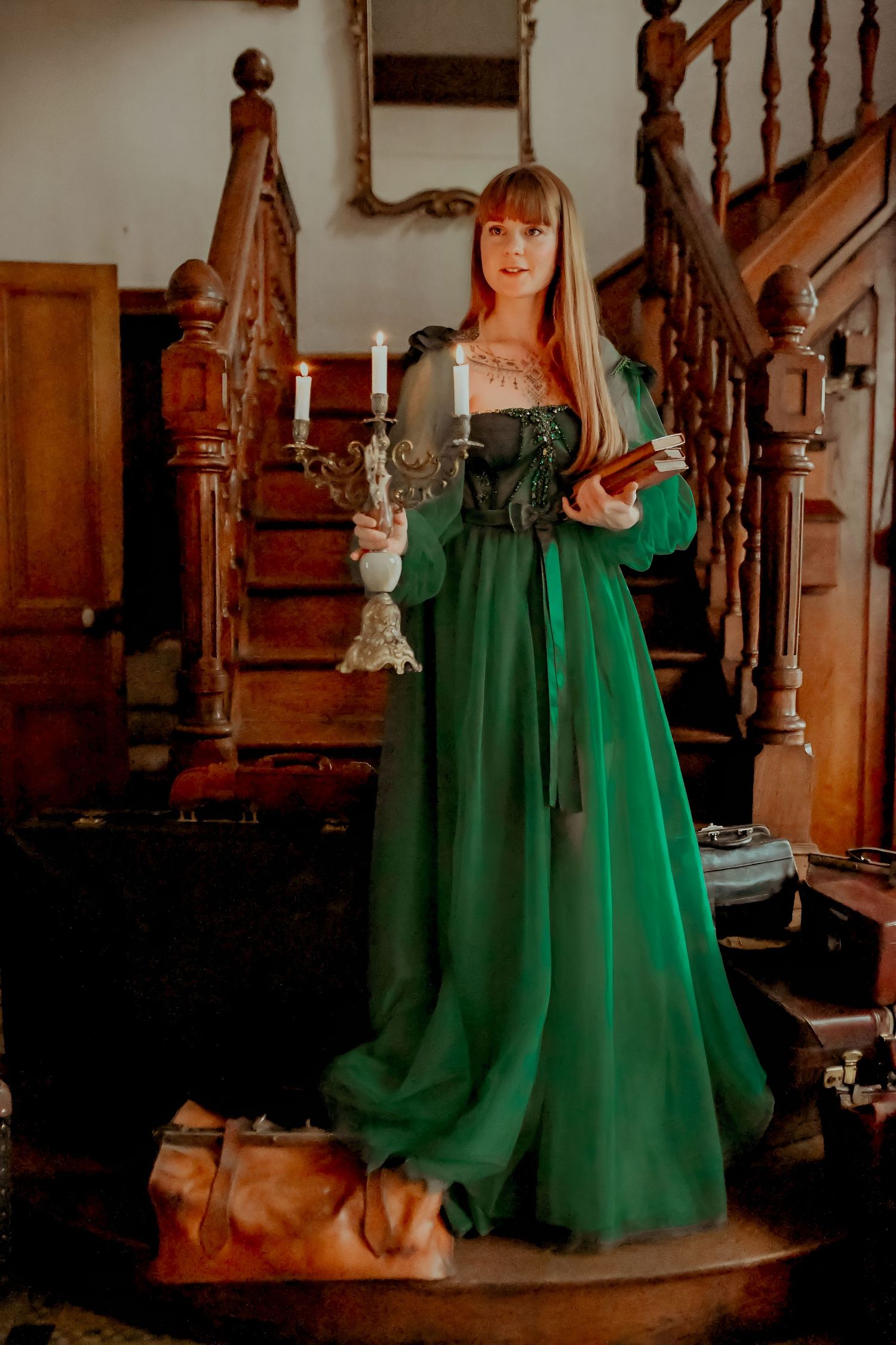 Elegant emerald green dress photographed near wooden staircase in vintage setting.