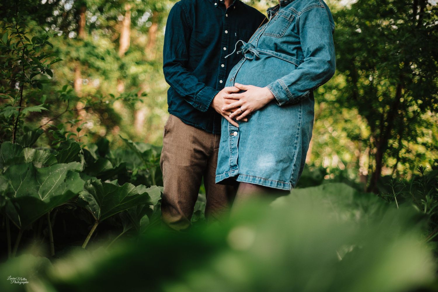 Intimate portrait of couple among lush green garden foliage.