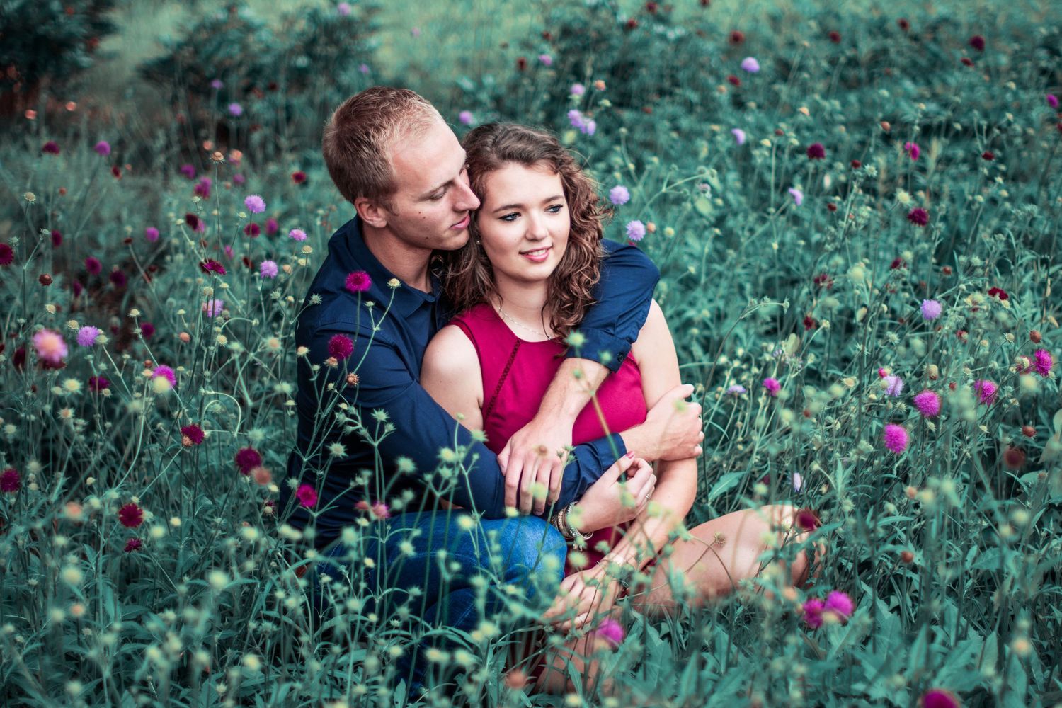Romantic moment captured in garden with pink flowers and greenery.