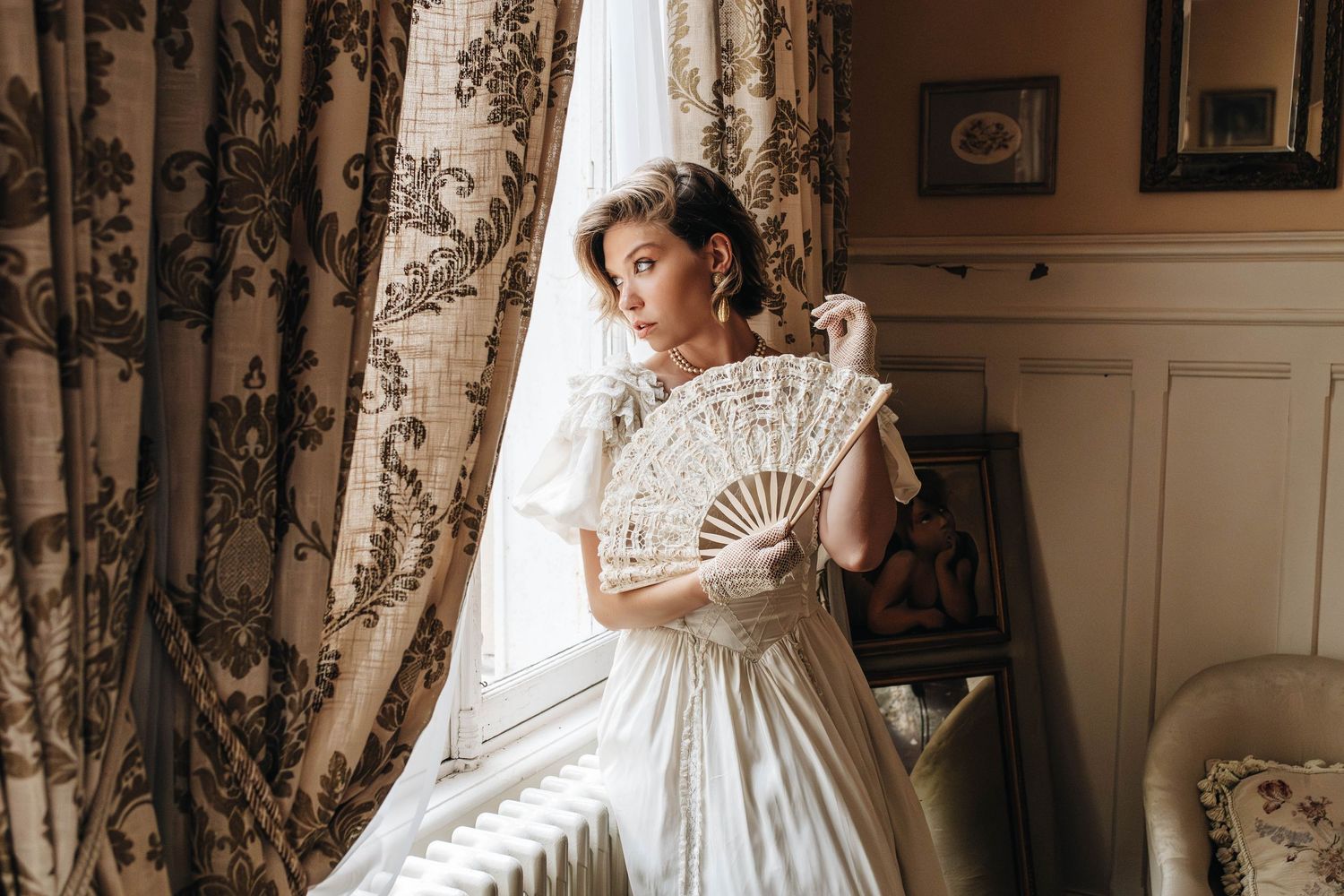 A vintage-styled interior with toile wallpaper and antique furniture creates a romantic atmosphere.