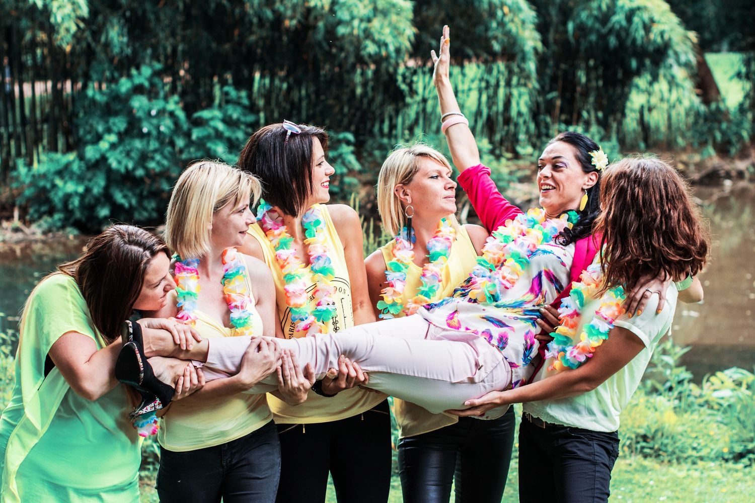 Group of friends having fun with props during an outdoor summer photoshoot.