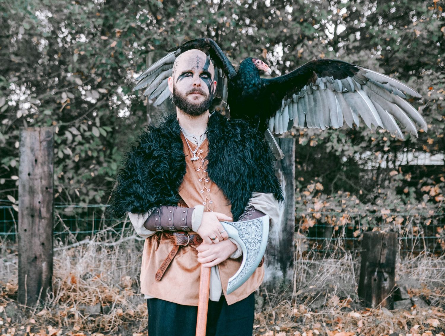 Dark fantasy themed outdoor portrait with falconry elements in autumn setting.