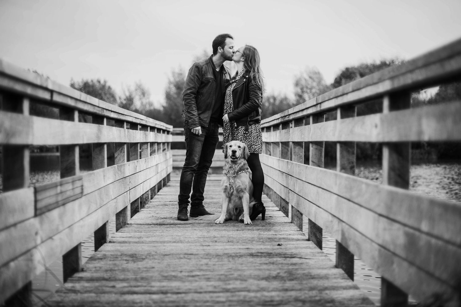Family walking along wooden boardwalk in black and white photography.