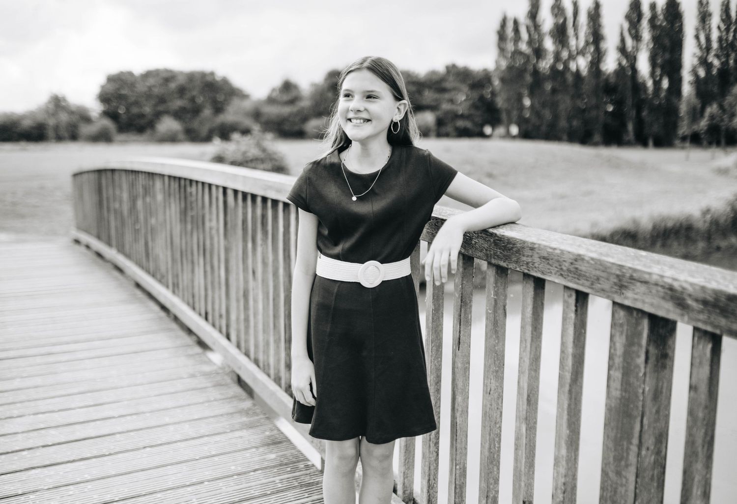 Series of black and white photos showing someone posing on a wooden bridge.