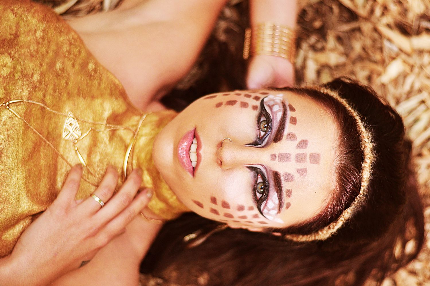 Artistic portrait series with gold tones and decorative face paint creating an ethereal mood.