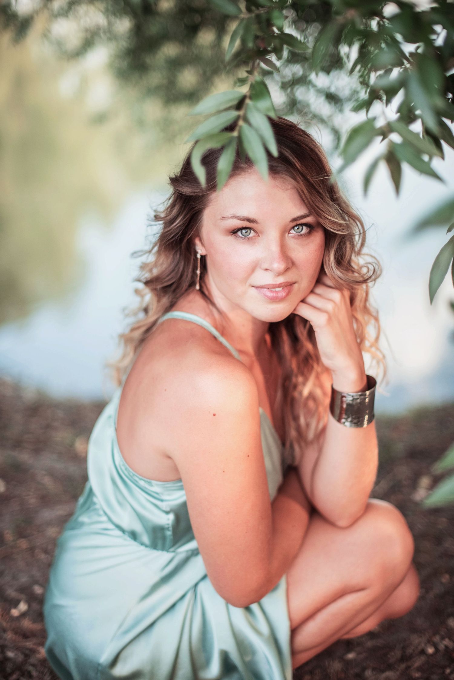 Dreamy portrait session under tree branches in mint green dress.