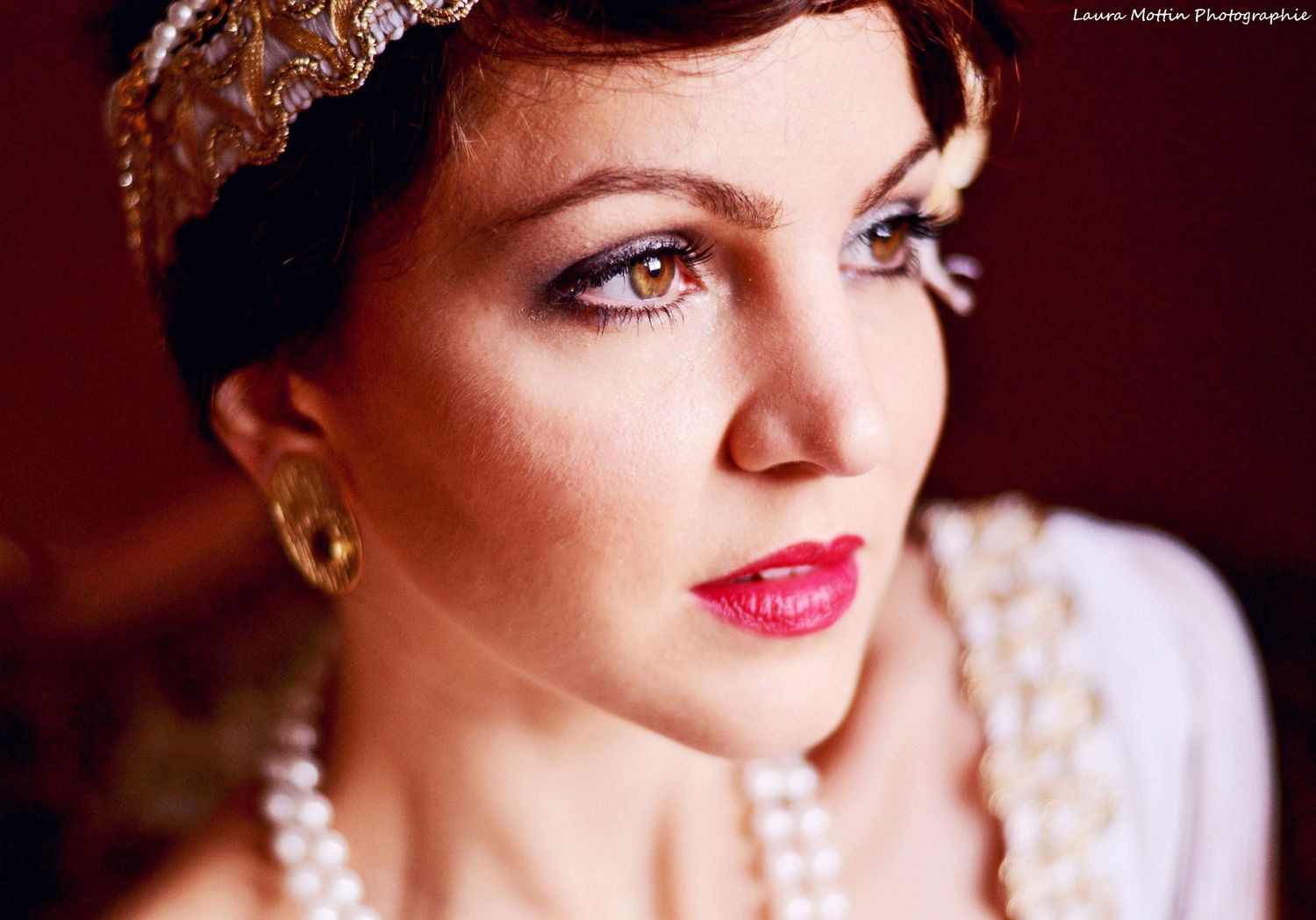 Classic vintage portrait featuring pearl accessories and red lipstick.
