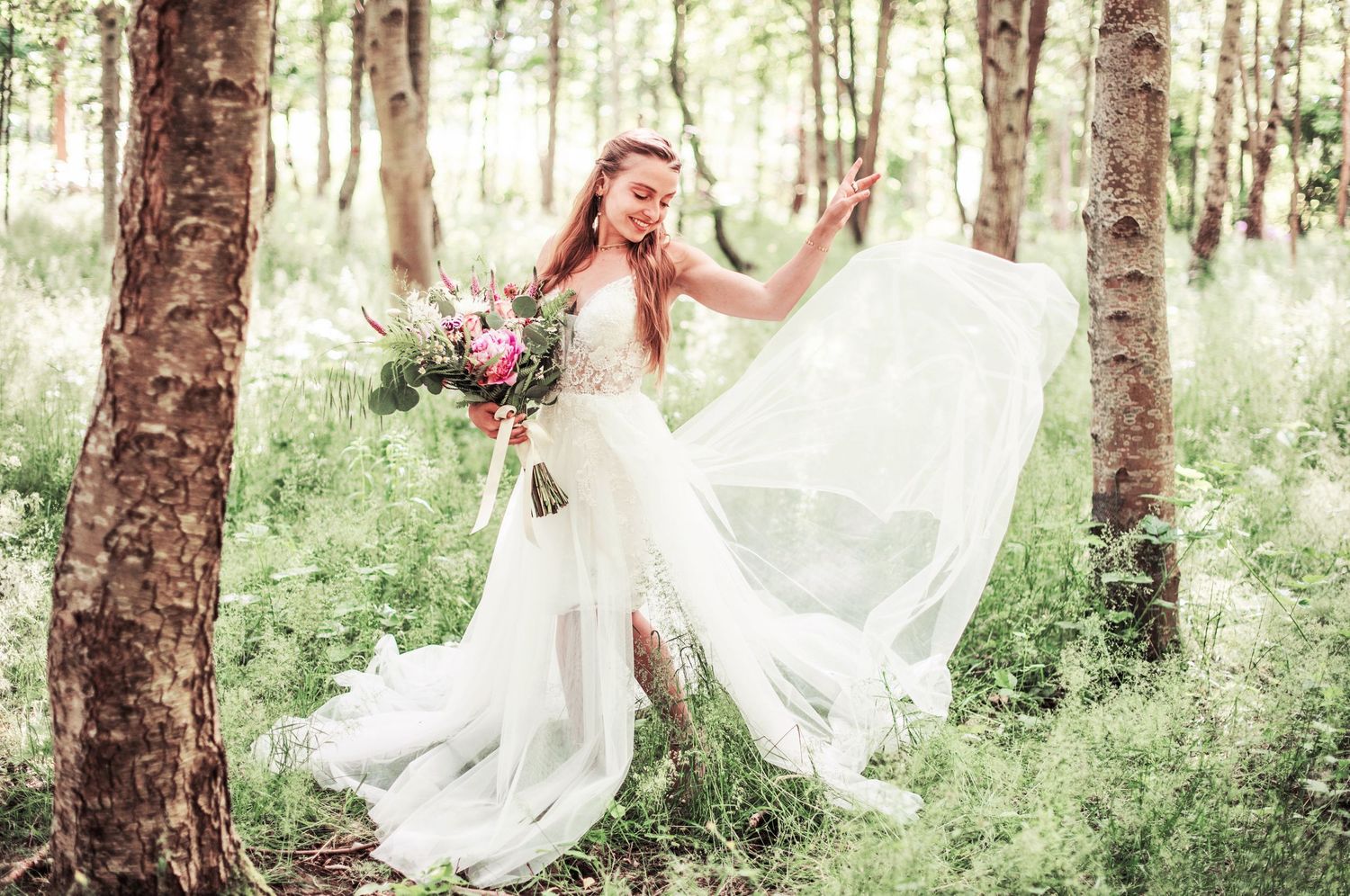 Dreamy forest photoshoot featuring a flowing white dress and natural woodland scenery.