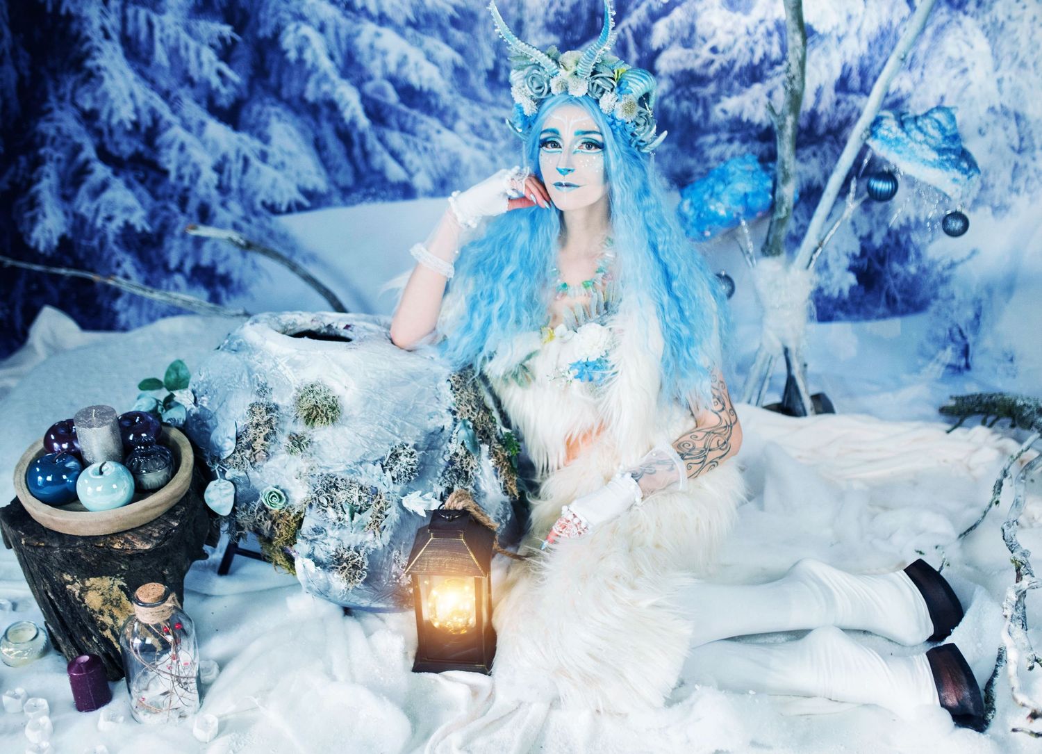 A winter fantasy scene with blue lighting features decorative elements and lanterns in the snow.
