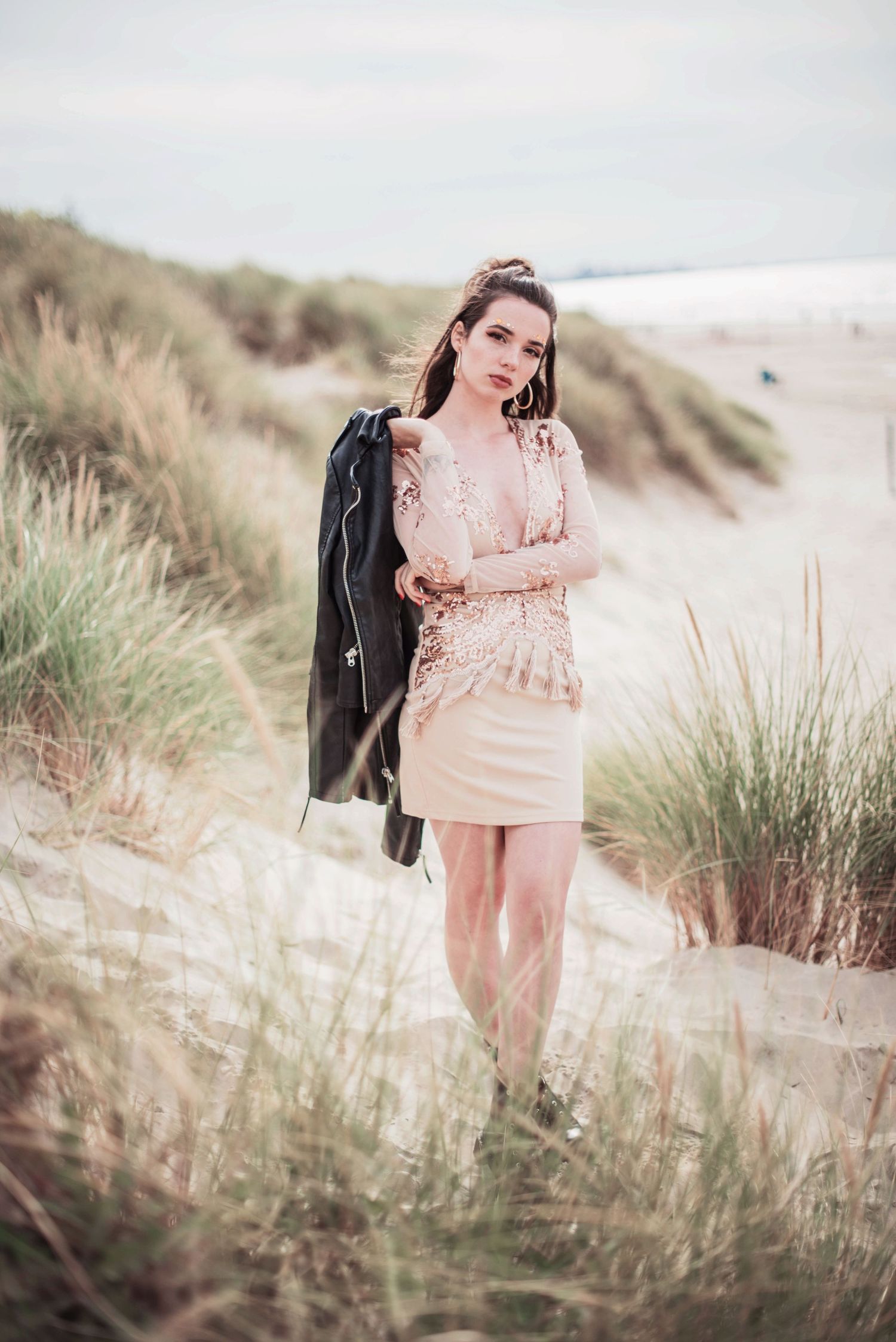 Beachwear fashion shoot among sand dunes with leather jacket and pink dress.