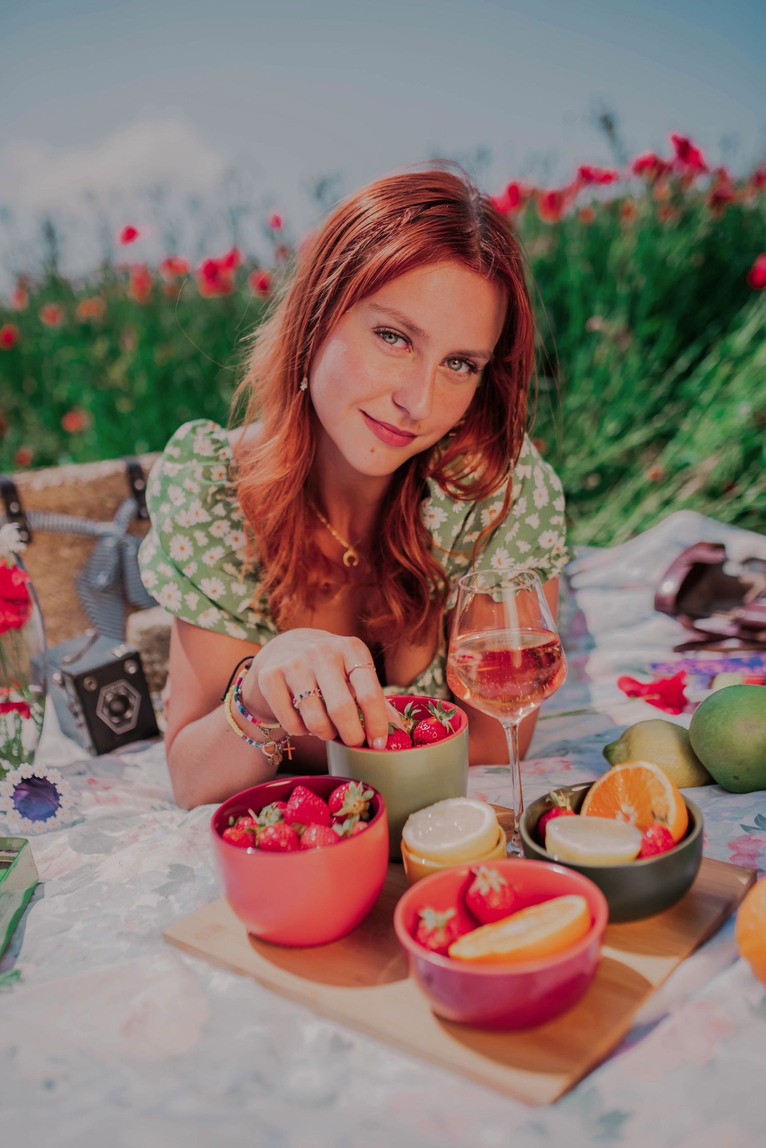 Colorful summer picnic spread with fresh berries and citrus fruits on a white blanket.