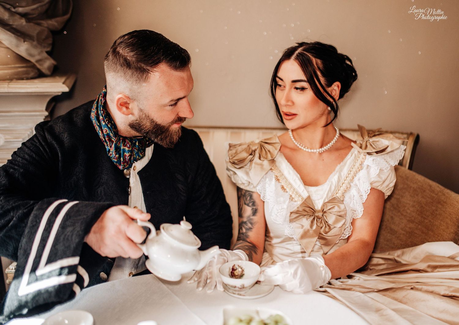 Vintage-style tea party setting with guests enjoying refreshments at a decorated table.
