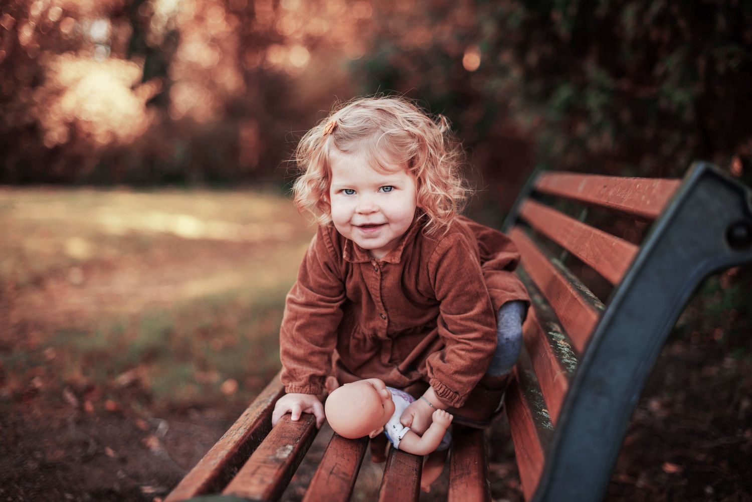 Playful autumn family photoshoot with brown and orange tones in an outdoor setting.