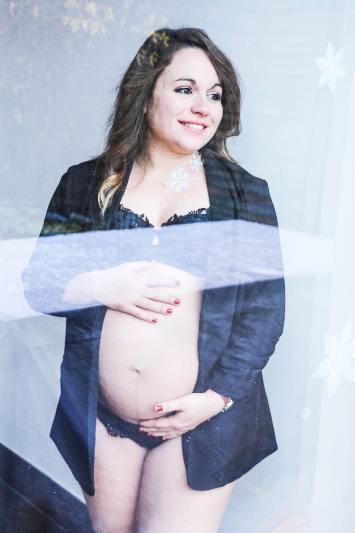Artistic maternity photos showing silhouette of pregnant woman in blue against light background.
