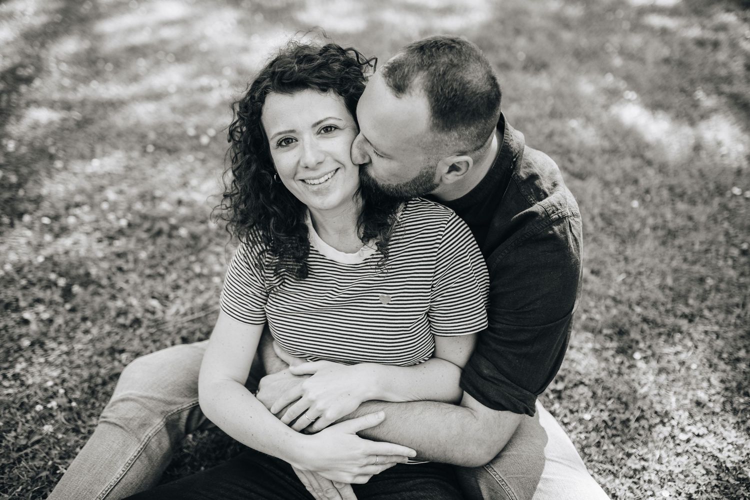 A romantic black and white photo sequence showing an intimate moment between a couple in a natural setting.