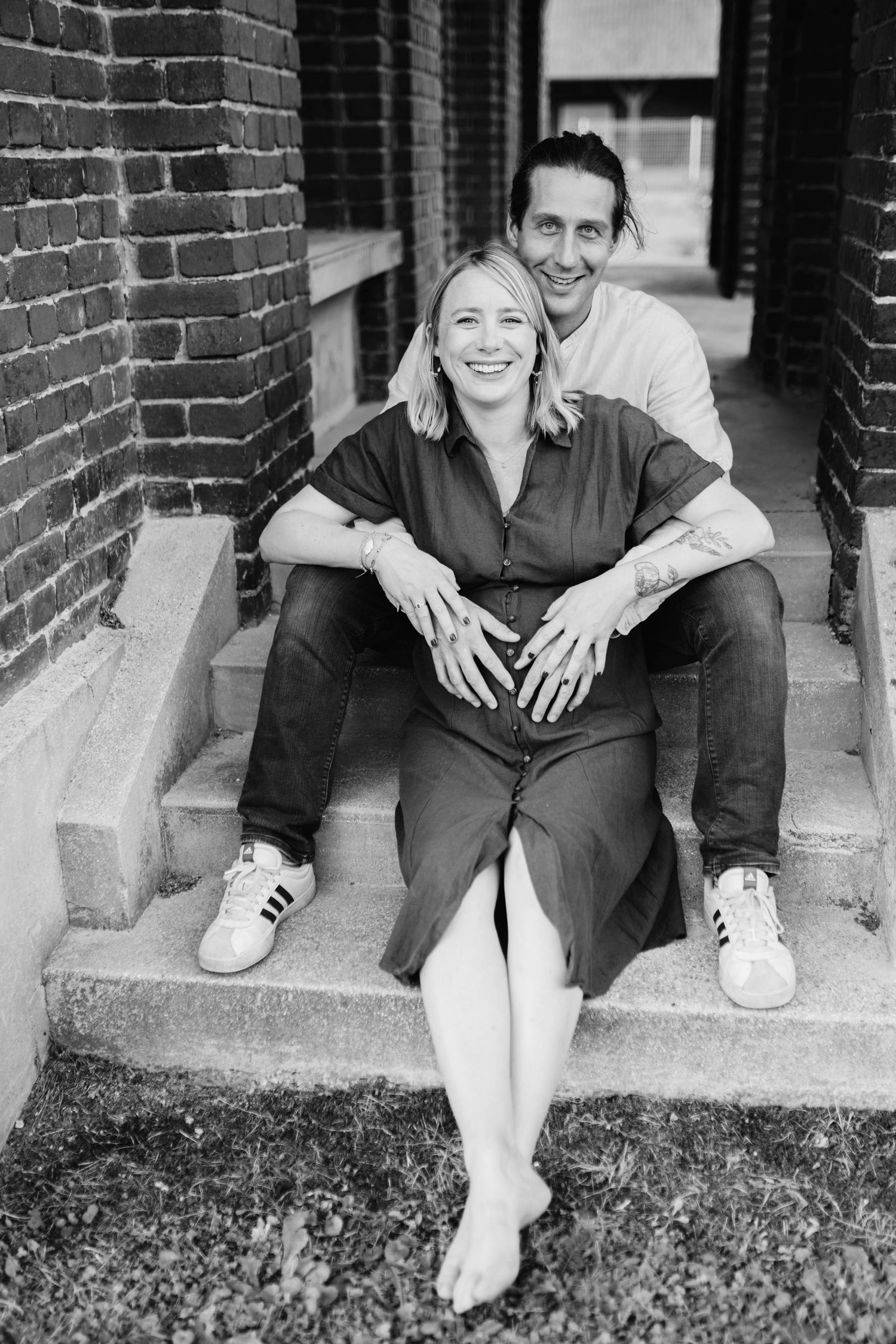 Black and white photos of a couple sitting casually on brick steps.