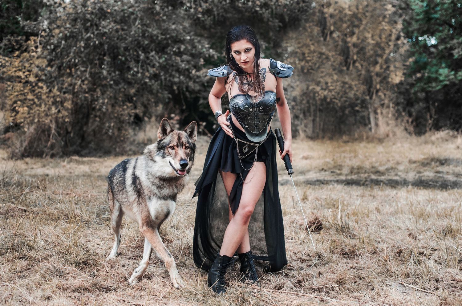 A person walks with a husky dog on a dirt path in a natural outdoor setting.