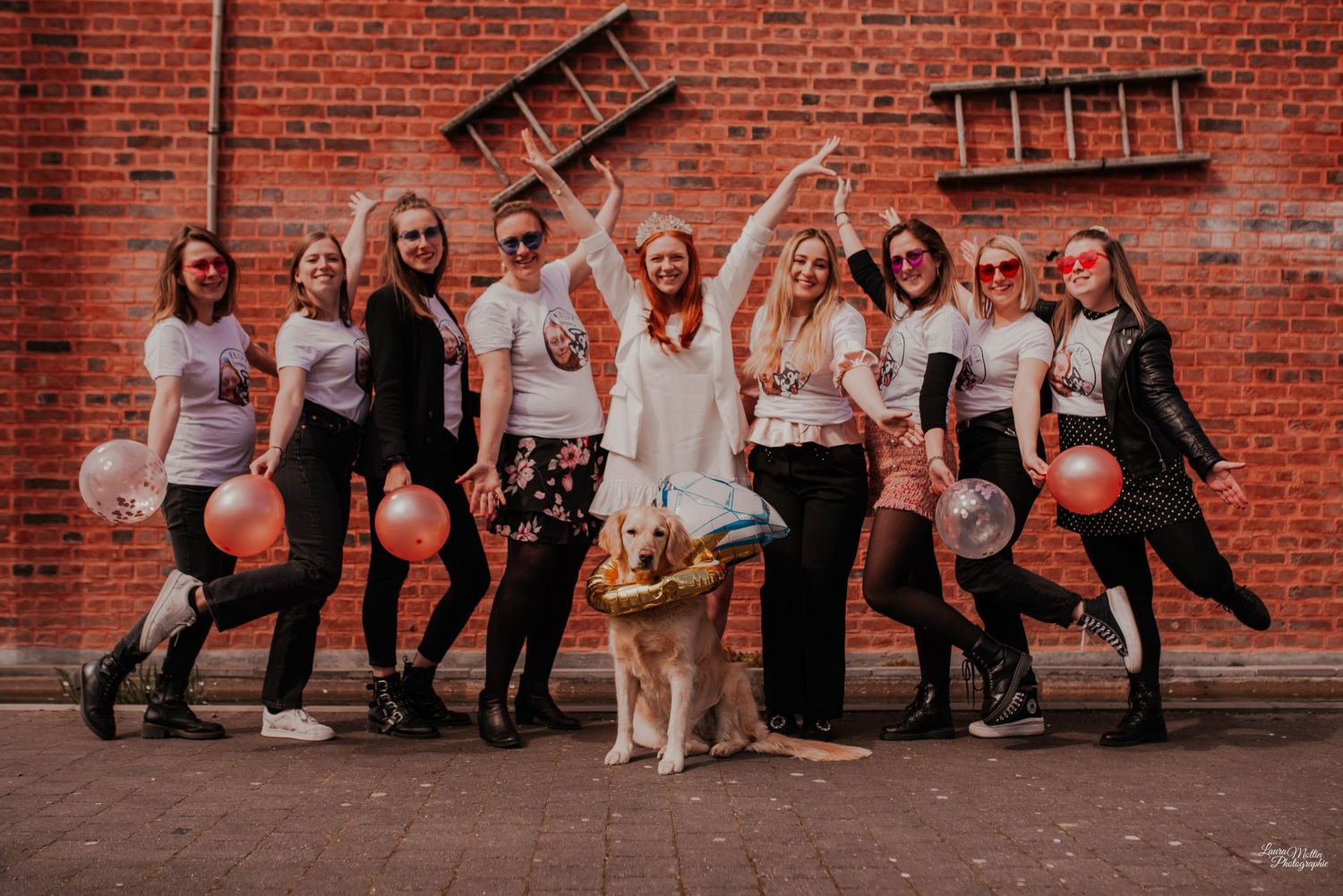 Group photo against red brick wall with coordinated outfits.