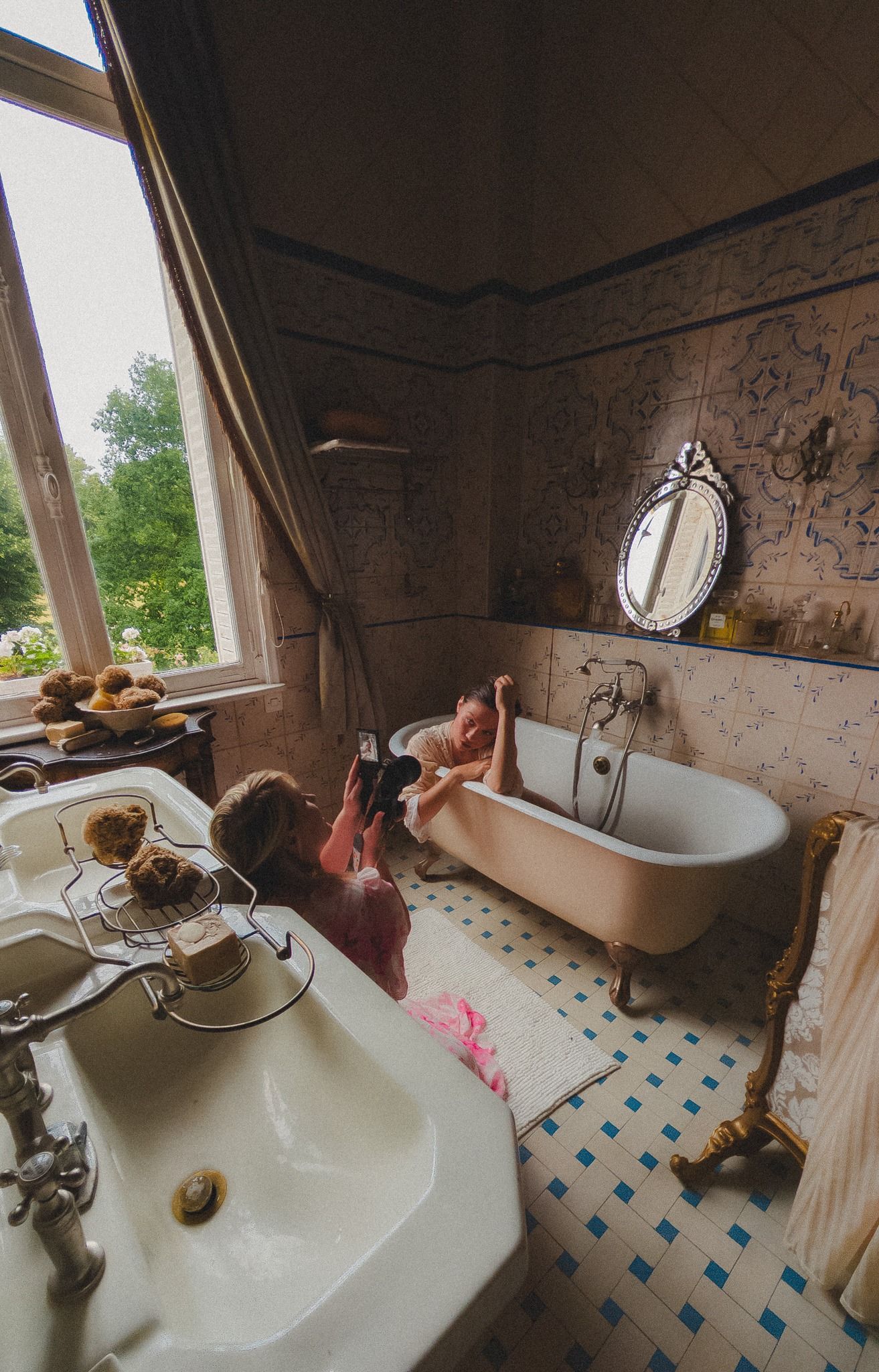 Vintage bathroom interior with clawfoot tub and ornate mirror.