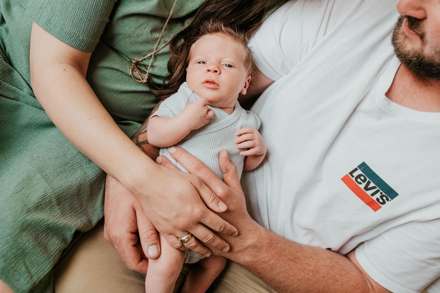 Tender moments of newborn baby care shown in soft green and white tones.