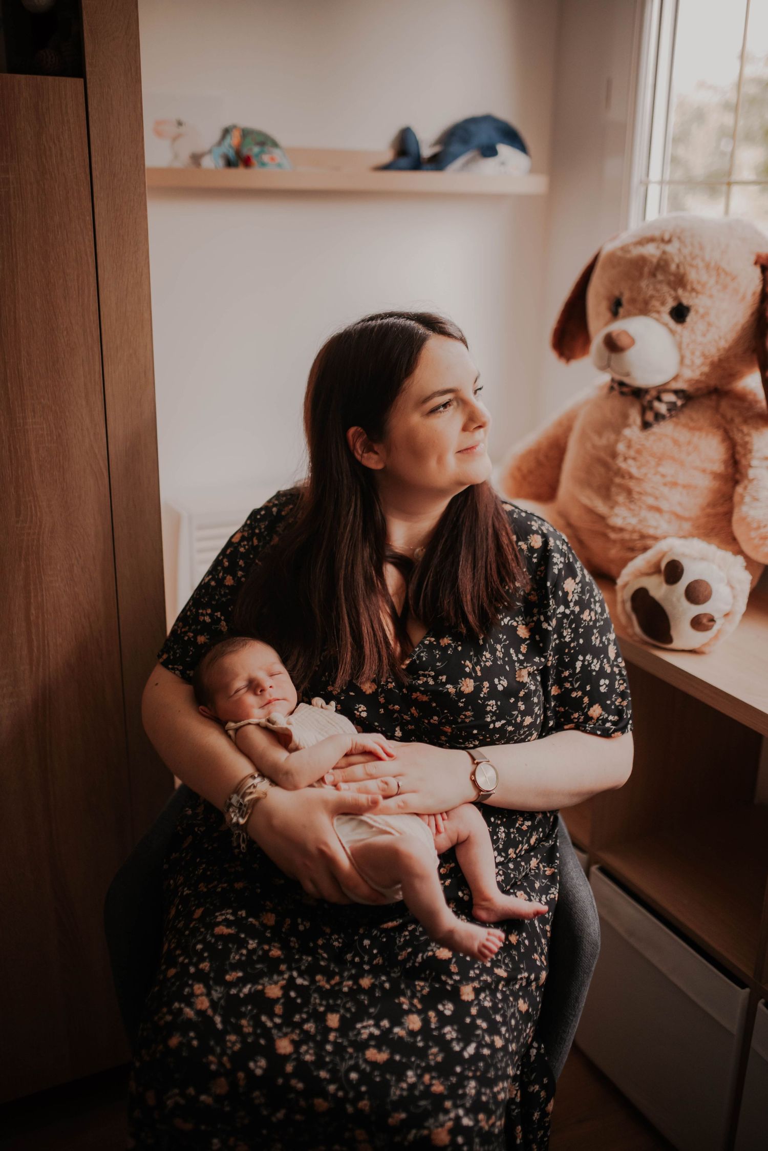Indoor lifestyle session showing parent and baby interactions near wooden furniture.