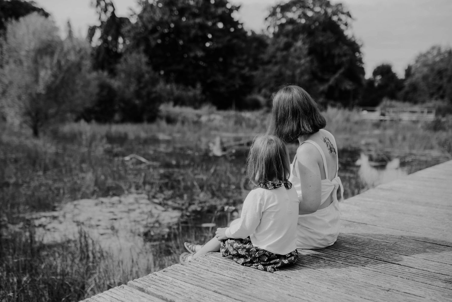 Black and white series showing joyful interactions on a wooden platform.