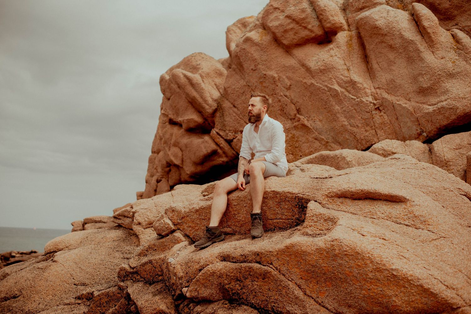 Dramatic desert photoshoot featuring red rock formations and natural earth tones.