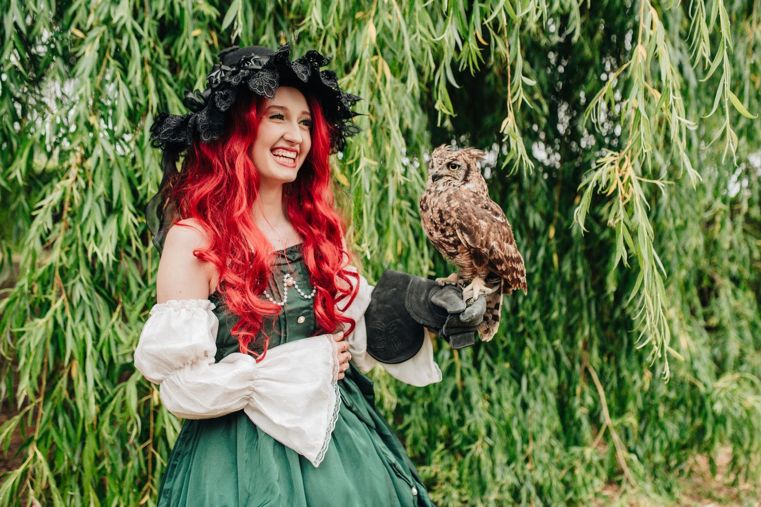 Fantasy-inspired photoshoot with willow trees and natural greenery in outdoor setting.