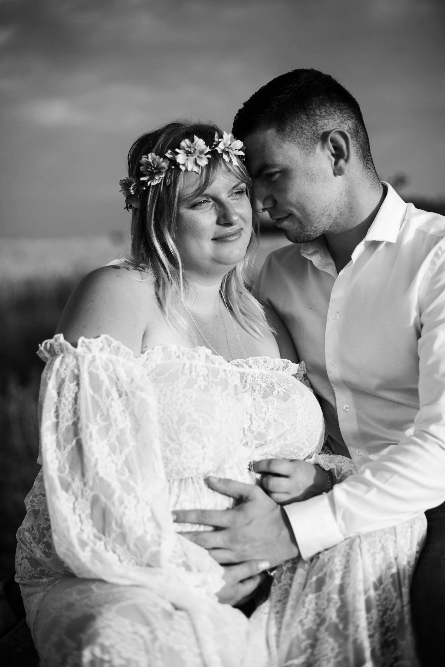 Intimate black and white maternity portrait in lace dress and floral crown.