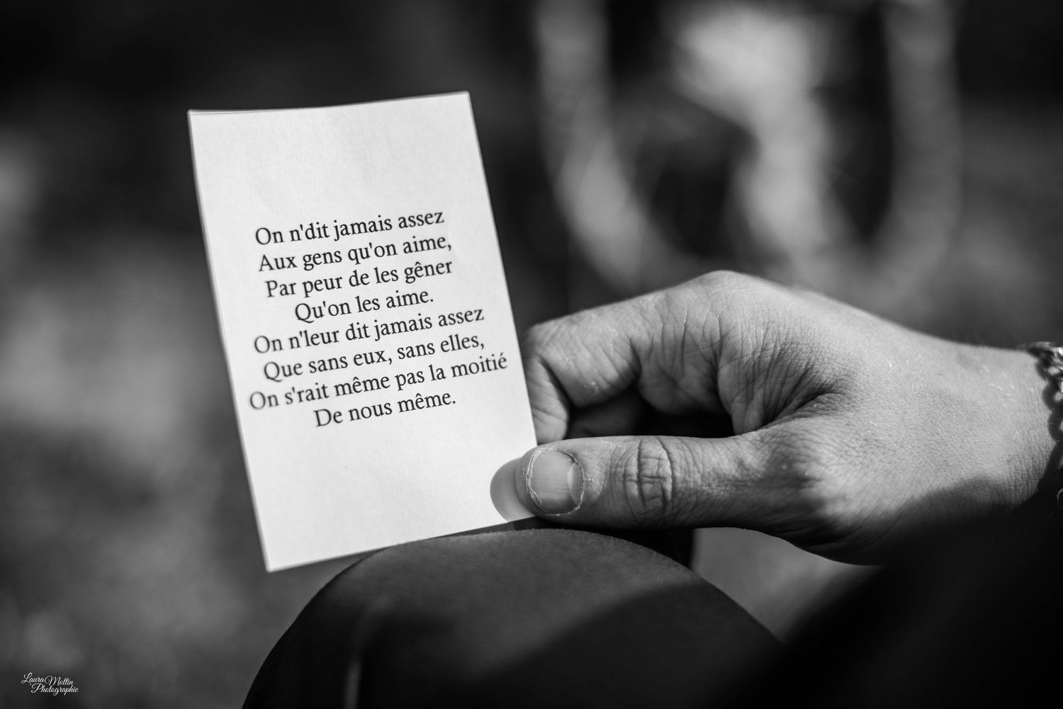 Black and white image of hands passing notes during a wedding ceremony.