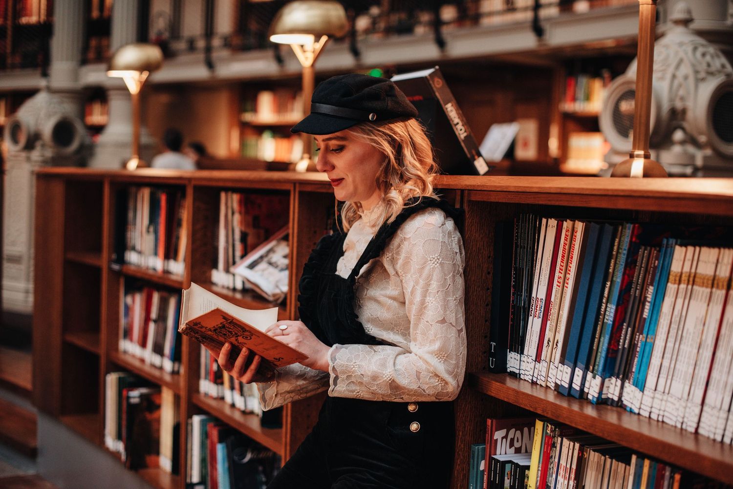 Bookshelves line the walls of a warmly lit library with a vintage atmosphere.