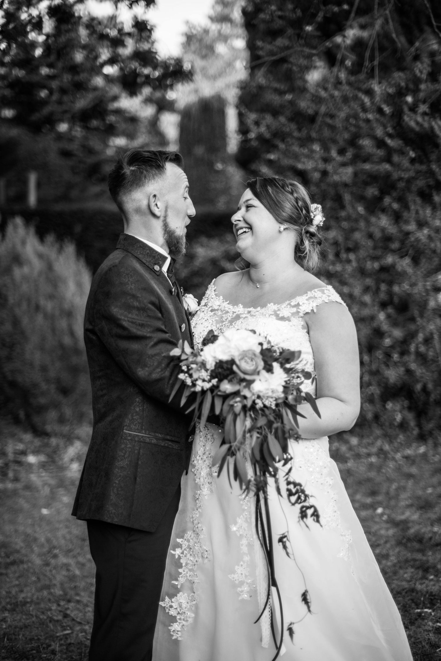 Black and white wedding portraits in a natural outdoor setting with bouquet.