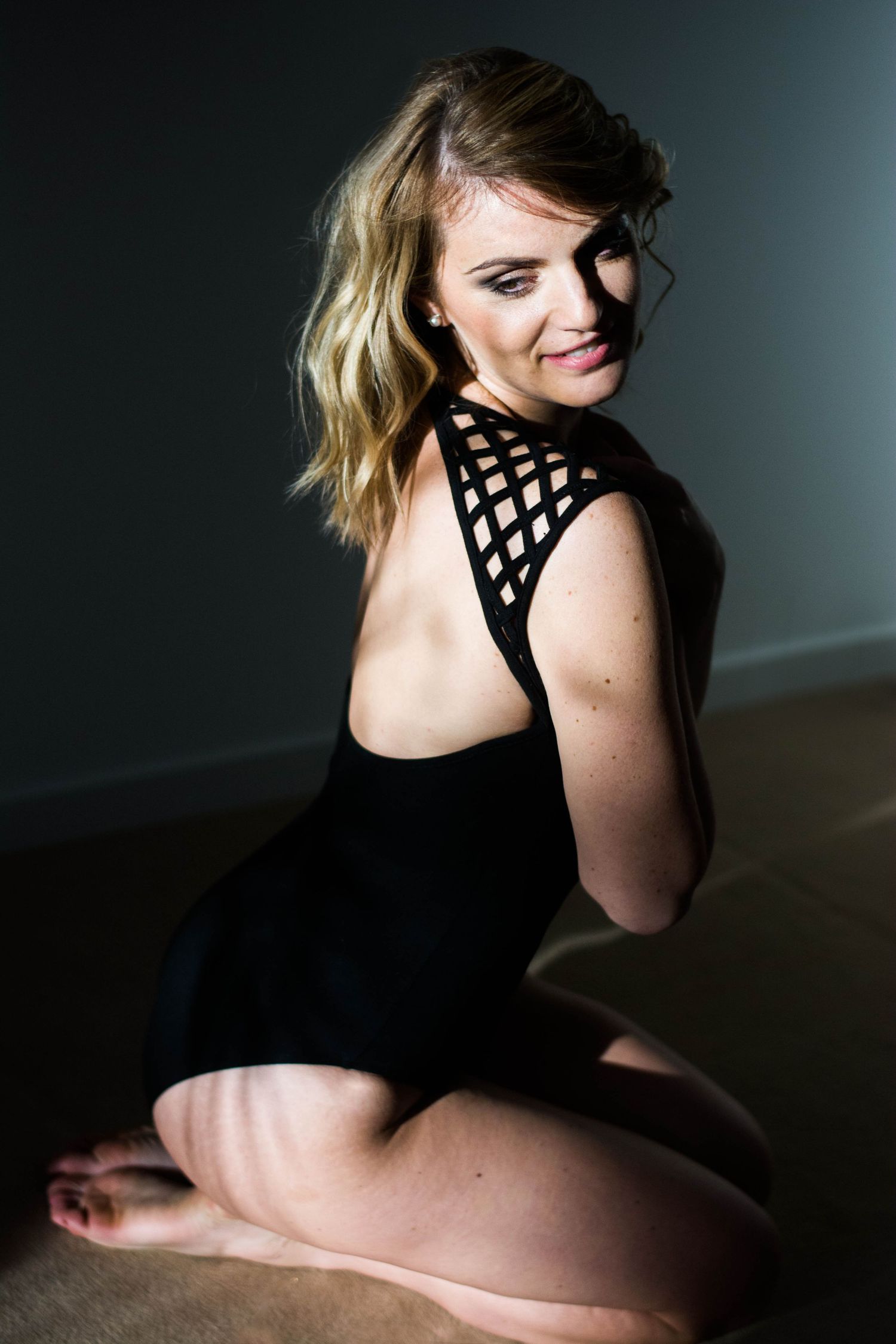 Artistic portrait series with black lattice-detail top in dramatic lighting.
