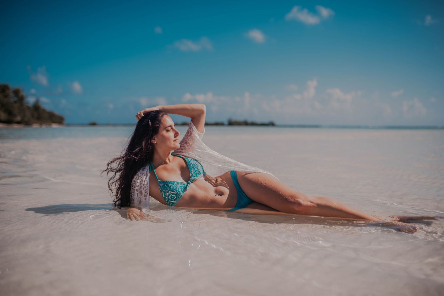 Scenic beach photoshoot with turquoise water and white sand under bright blue skies.
