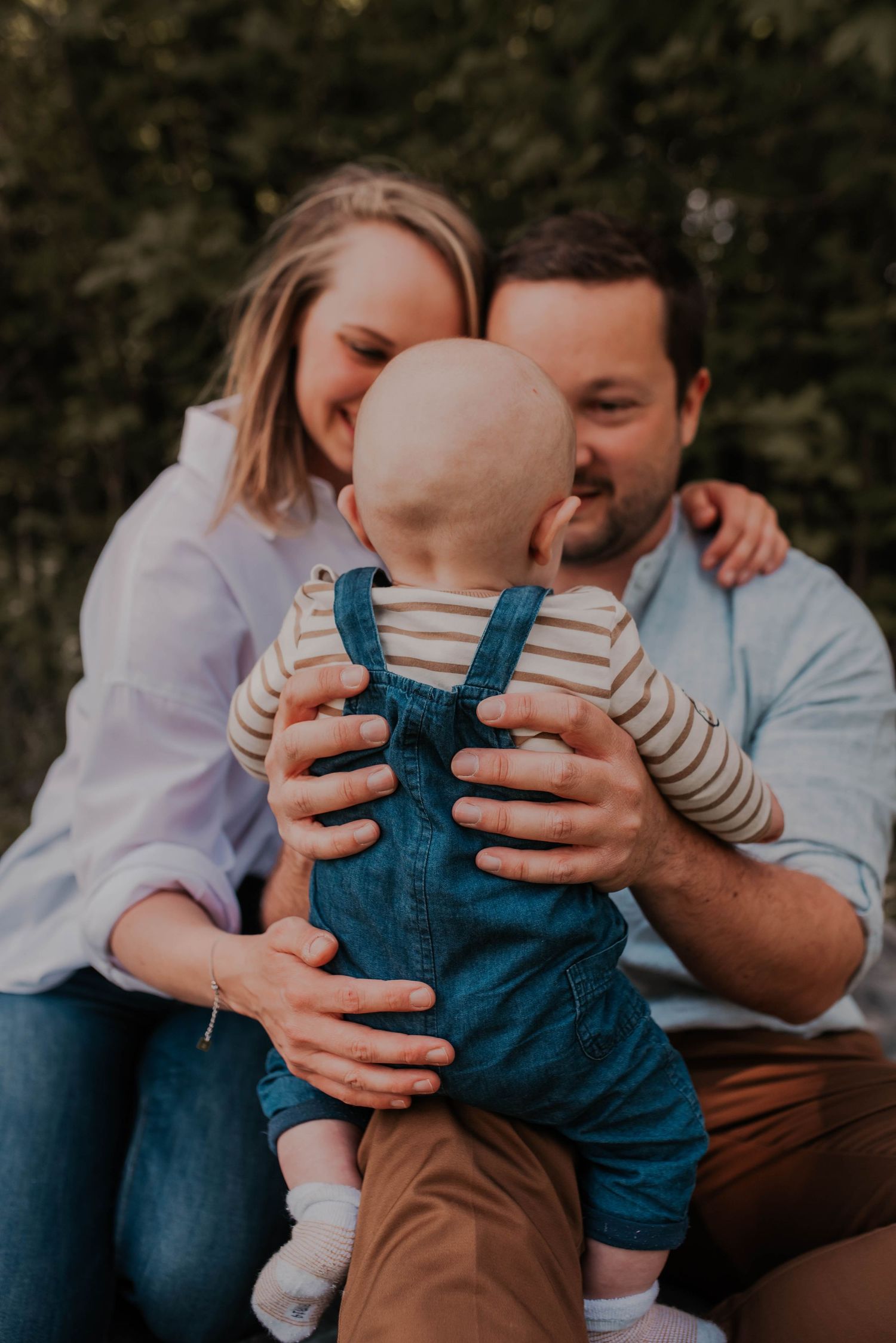 Family photo series showing parents playing with baby wearing blue overalls.